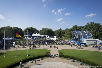Blick in den Schlosspark mit Besuchern und der Bühne