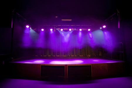 Das Bild zeigt die leere Bühne mit Beleuchtung im Privatclub in Berlin