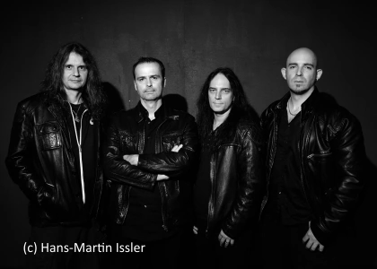 Das Bild zeigt die vier Musiker von Blind Guardian. Hansi Kürsch verschränkt die Arme und es ist in Schwarz Weiß gehalten