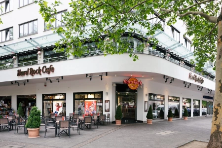 Der Eingangsbereich des Hard Rock Cafe in Berlin mit Bürgersteig und Stühlen des Aussencafes