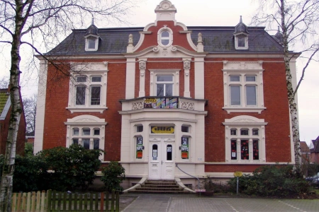 Die Fassade des Jugendzentrum Leer ist in rot und weißgehalten, das villenähnliche Gebäude hat eine lange Treppe am Eingang