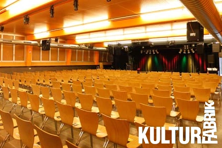 Mehrere Stühle in Sitzreihen vor der Bühne der Kulturfabrik Kufstein
