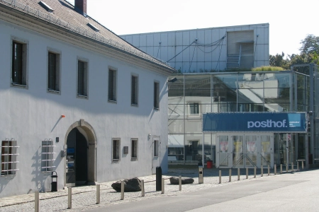 Der Posthof Linz von aussen mit einer Baustelle und dem bürgersteig