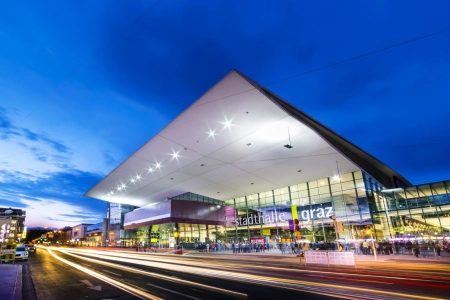 Die Stadthalle Graz ist ein modernes Bauwerk aus Glas und Beton, davor herrscht immer dichter Verkehr