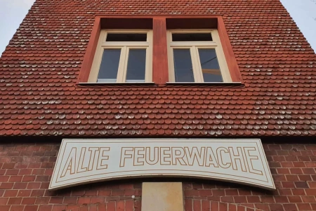 Am Turm der Alten Feuerwache Bad Nauheim hängt das Schild mit dem Namen des Jugendclubs. Die Fassade selber ist aus roten Ziegelsteinen