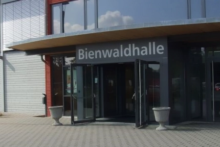 Der Eingangsbereich der Bienwaldhalle Kandel. Mit zwei großen Pflanzschalen und geöffneten Türen.