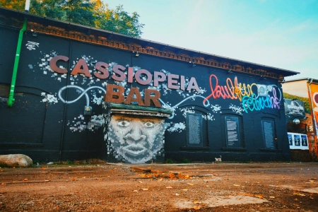 Das Cassiopeia Berlin ist von aussen mit Graffiti verziert. Der Eingang führt durch einen großen gesprühten Kopf.