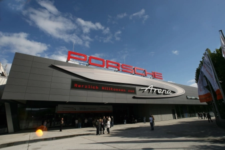 Die moderne Halle der Porsche Arena Stuttgart von aussen. Hoch oben prangt der rote Schriftzug Porsche