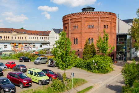 Die Location Alter Gasometer Zwickau von aussen. Zu sehen sind ebenfalls Autos auf dem angrenzenden Parkplatz.