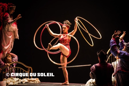 Der Cirque du Soleil lädt zum Träumen ein. Eine Künstlerin zeigt auf der Bühne eine Hula Hoop Nummer mit mehreren Ringen.