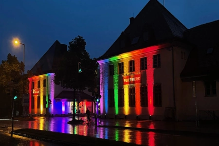Das Feierwerk München iist in bunte Lichter getaucht. Die Farben erinnern an die Regenbogenflagge der Schwulencommunity. Das Feierwerk München setzt so ein zeichen für Vielfalt und Toleranz