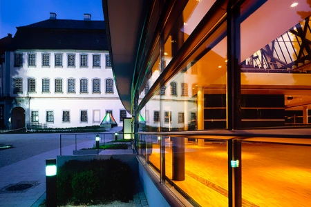 Das Kulturhaus Laupheim liegt direkt am Schloss, welches sich in den Glasscheiben der Location spiegelt.