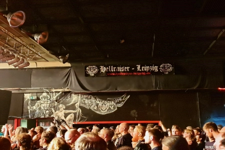 Der Innenraum bei einem Konzert im Hellraiser Leipzig ist voll mit Gästen. An der Wand hängt ein Banner mit dem Namen der Location