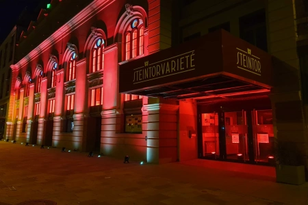 Das Steintor Varieté Halle leuchtet bei Nacht rot, um auf die Krise in der vanstaltungswirtschaft hinzuweisen