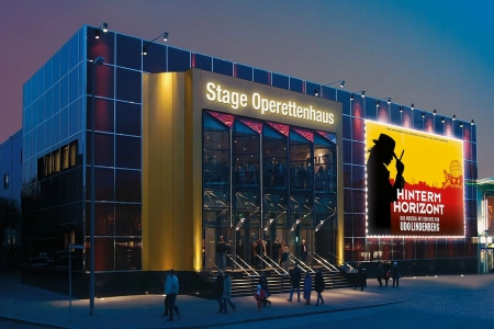 Die moderne Glasfassade des Stageoperettenhaus Hamburg, täuscht über das wahre Alter, des Theaters hinweg. Hell erleuchtet und modern stellt der historische Bau sich dar.