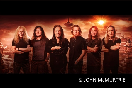 Die sechs Musiker von Iron Maiden stehen mit verschränkten Armen nebeneinander. Im Hintergrund sind japanische Tempel zu sehen.