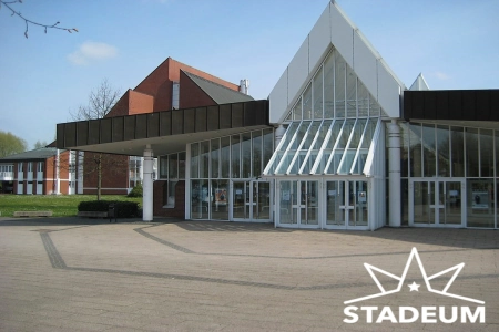 Das Stadeum Stade ist ein verglastes Gebäude mit breiten Eingängen. Der Vorplatz ist eben gehalten.