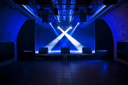 Ein Blick auf die Bühne des Dynamo Zürich. Die Gewölbeartige Halle ist in blaues Licht getaucht.