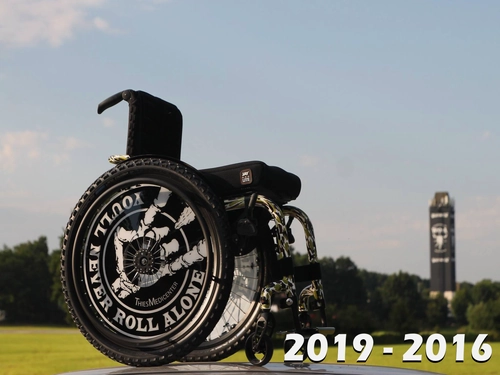 Oftmals werden Wir in der Presse mit Rollstuhlfahrern in Verbindung gebracht. Hier steht ein Rollstuhl in Wacken im Hintergrund ist der Wacken Tower zu sehen