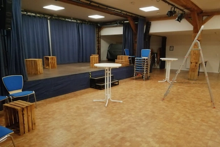 Die Bühne des Brakula Hamburg. Davor stehen noch eine Leiter, ein Tisch und einige Stühle. Auf der Bühne befinden sich Holzkisten.